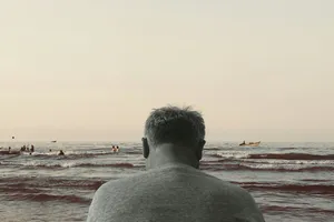 Фотография человека у моря из материала 404 Media про повторяющиеся истории LLM о маячнике Elias Thorne