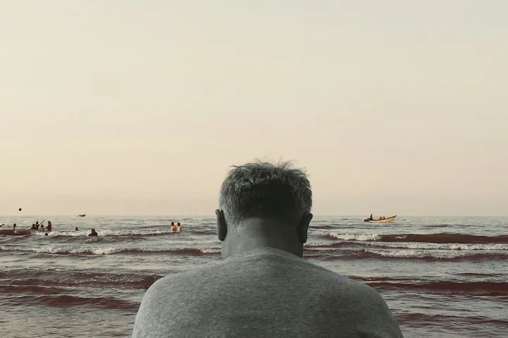 Фотография человека у моря из материала 404 Media про повторяющиеся истории LLM о маячнике Elias Thorne